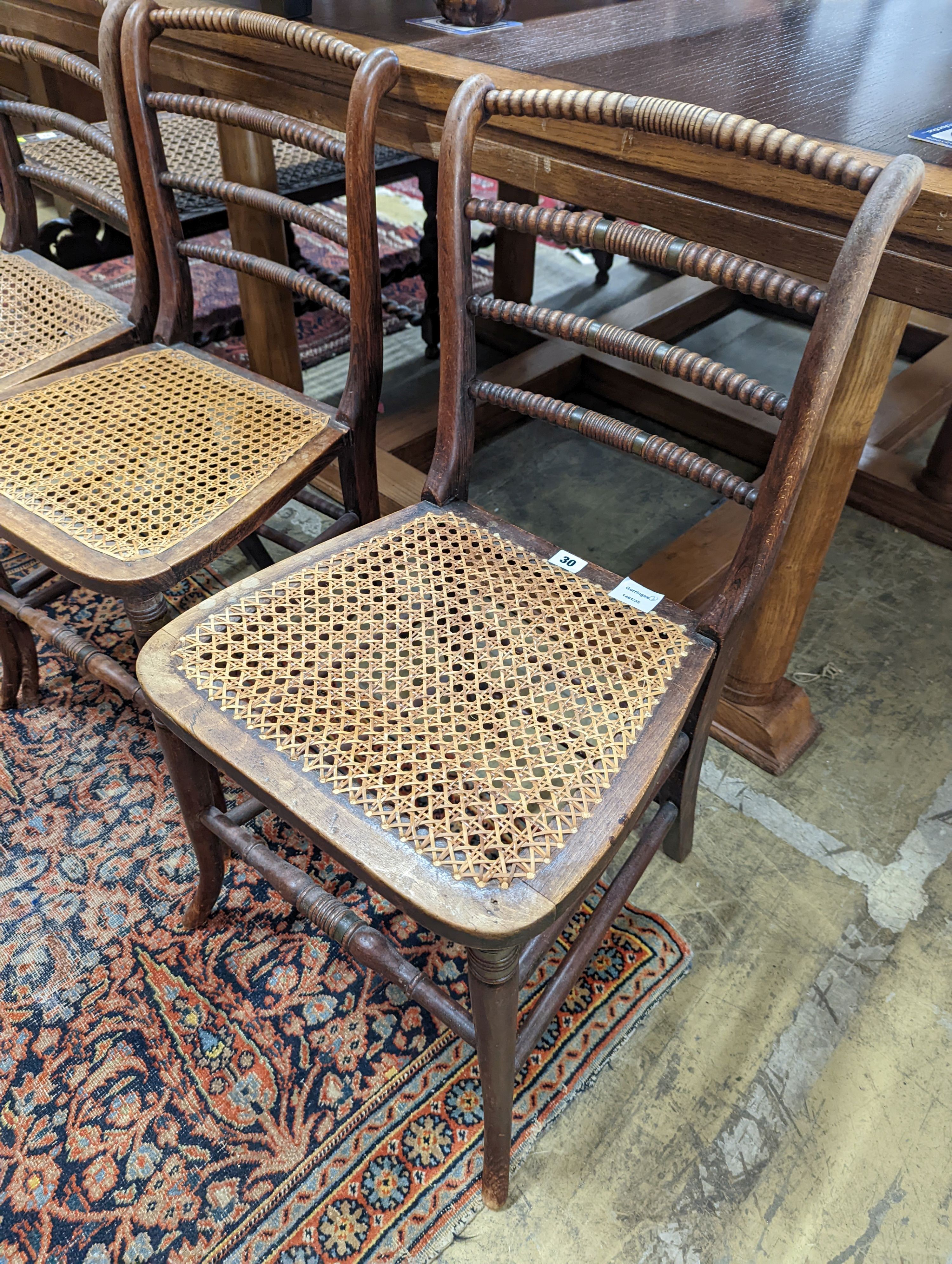 A set of three Regency provincial simulated rosewood cane seated dining chairs